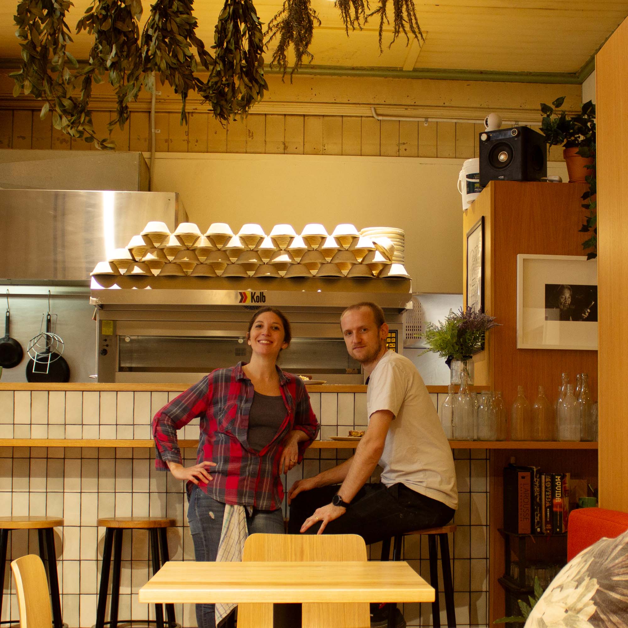 two people sitting at bar in eatery